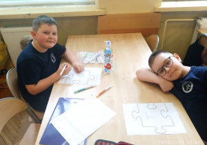 Uczniowie siedzą przy stoliku