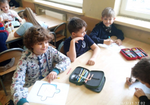 Uczniowie siedzą przy stoliku