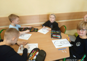 Uczniowie siedzą przy stoliku