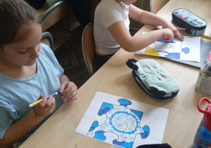 Uczniowie siedzą przy stoliku