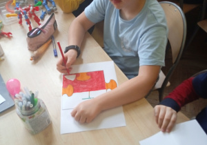 Uczniowie siedzą przy stoliku