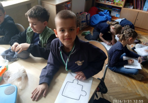 Uczniowie siedzą przy stoliku