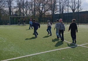 Dzieci podczas wspólnej gry w piłkę na boisku