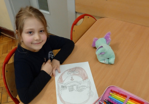 Uczennica siedzi w ławce