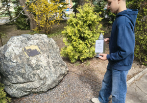 Uczeń stawia znicz pod pomnikiem