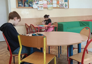 Uczniowie pracują przy stolikach podczas zajęć