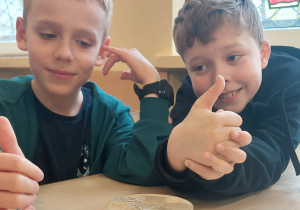 Uczniowie siedzą w ławce