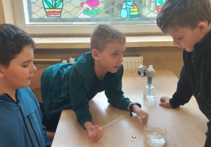 Uczniowie wykonują doświadczenie z wodą