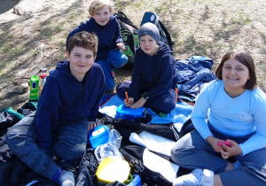 Uczniowie siedzą na kocu