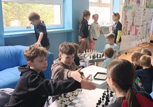 Dzieci w czasie przerwy ćwiczą się w grze w szachy i warcaby