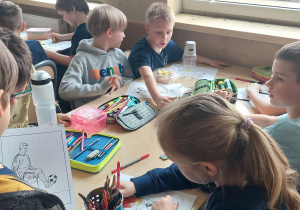 Uczniowie pracują przy stoliku