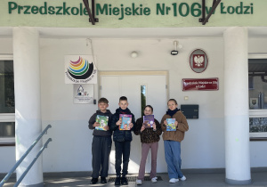 Uczniowie stoją przed wejściem do przedszkola