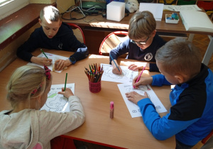 Uczniowie pracują przy stoliku