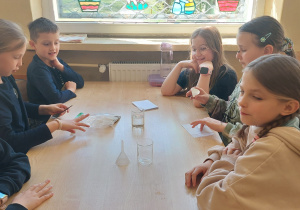 Uczniowie pracują przy stoliku