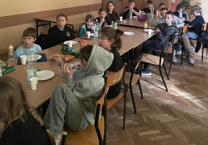 Uczniowie siedzą przy stole