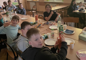 Uczniowie siedzą przy stole