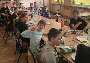 Uczniowie siedzą przy stole