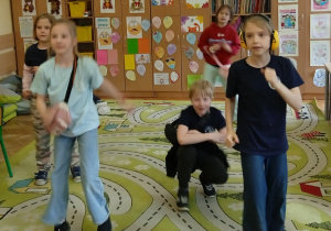 Uczniowie tańczą na dywanie