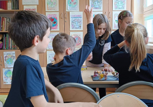 Uczniowie wykonują w grupie ćwiczenie przy stoliku