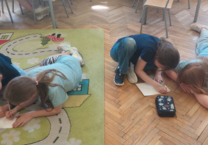 Uczniowie pracują na dywanie