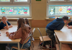 Uczniowie siedzą przy stolikach