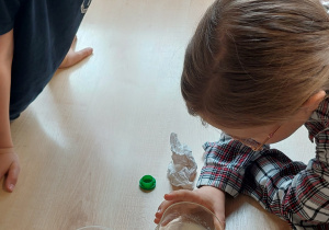 Uczniowie wykonują doświadczenie