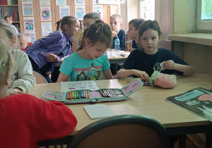 Dzieci oglądają bajkę Król Maciuś I wykonując ćwiczenia plastyczne