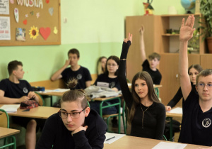 Uczniowie siedzą w ławkach