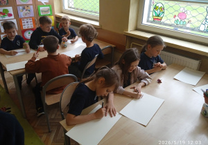 Uczniowie pracyją przy stoliku
