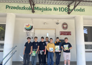 Uczniowie stoją przed przedszkolem