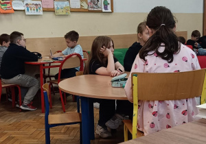 Dzieci przy stolikach wykonują ćwiczenie na pomysłowość