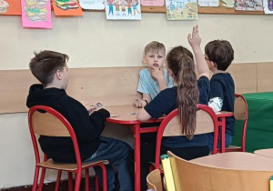 Dzieci zgłaszają się do odpowiedzi przy stoliku