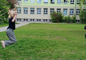 Dzieci wspólnie wykonują zabawę ze skakanką na świeżym powietrzu