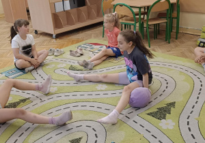 Dzieci wykonują ćwiczenie na dywanie