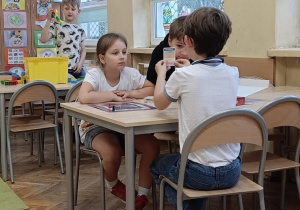 Dzieci wspólnie przy stoliku pracują na zajęciach