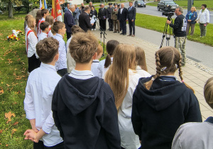 Uczniowie stoją przy pomniku