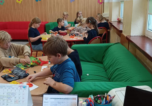 Dzieci wykonują pracę plastyczną o jesieni