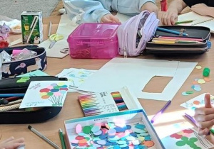 Uczniowie wykonują prace plastyczną przy stoliku