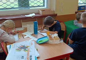 Dzieci tworzą pracę z okazji Dnia Nauczyciela