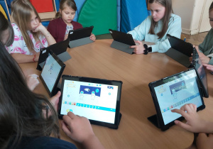 Uczniowie pracują na tabletach, tworzą aplikację w programie Scratch Junior.