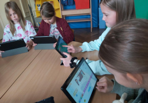 Uczniowie pracują na tabletach, tworzą aplikację w programie Scratch Junior.