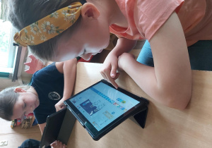 Uczniowie pracują na tabletach, tworzą aplikację w programie Scratch Junior.