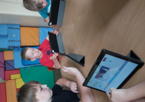 Uczniowie pracują na tabletach, tworzą aplikację w programie Scratch Junior.