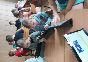 Uczniowie pracują na tabletach, tworzą aplikację w programie Scratch Junior.