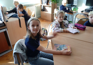 Uczniowie w bibliotece szkolnej z książkami