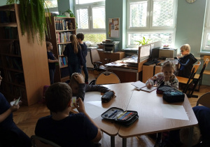 Uczniowie w bibliotece szkolnej z książkami