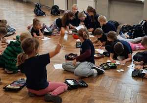 Dzieci wykonują w grupie prace plastyczną o sporcie