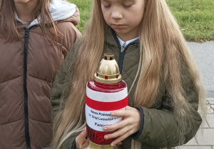 Uczennice stoją ze zniczem