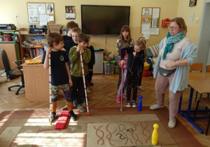 Dzieci poruszają się pokonując przeszkody na dywanie